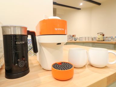 A kitchen counter with a Nespresso machine and a RAFOW milk frother next to two white mugs at Josie in Pentewan