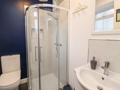 A bathroom with a shower enclosure toilet and sink at 2A Front Street in Embleton