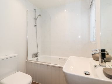 A bathroom with a toilet sink and bathtub with shower at Bowness Bay Lodge Oakside 16 Fallbarrow Park near Bowness-On-Windermere