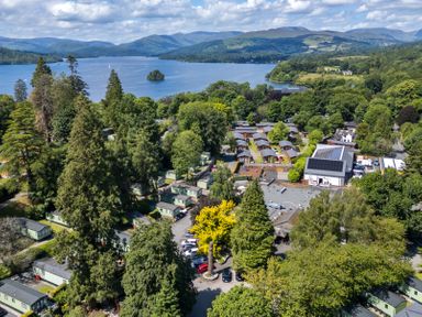 A holiday park with cabins and parking surrounded by trees near a lake and hills at Bowness Bay Lodge Oakside 16 Fallbarrow Park near Bowness-On-Windermere