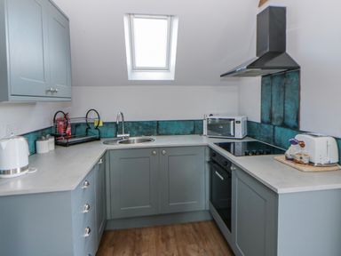 A kitchen with cabinets, sink, and appliances at Valley View Hideaway in Ffostrasol