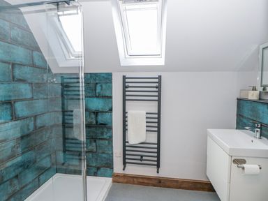 A bathroom with a shower and sink at Valley View Hideaway in Ffostrasol