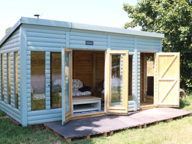 An outdoor structure with open doors and furniture at Holmside Audley Brow near Market Drayton