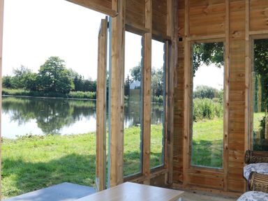 A room with large windows overlooking a lake at Holmside Audley Brow near Market Drayton