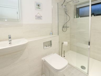 A bathroom with a white sink toilet and a glass enclosed shower at 2 Strathtay Lodges in Aberfeldy