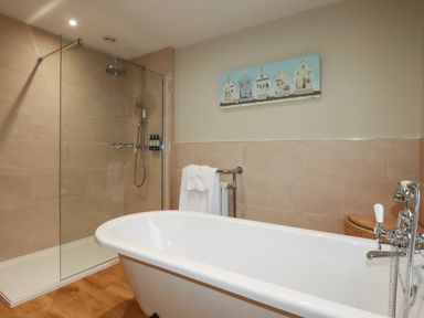 A bathroom with a freestanding bathtub and a glass-enclosed shower at Tretoil Farm House in Bodmin