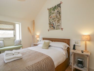 A bedroom with a bed and soft furnishings at The Little Loft in Burford