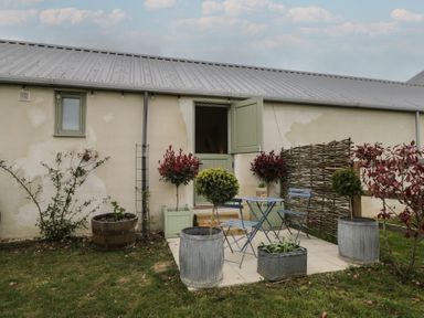 An outdoor patio with a table and chairs at The Little Loft in Burford
