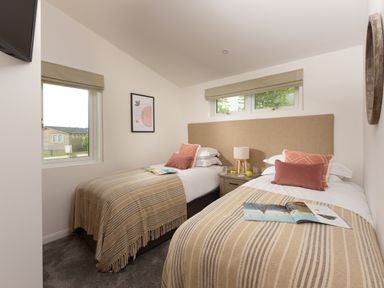 A bedroom with two single beds side by side with striped blankets and pillows at 5 Southern Place in Dobwalls
