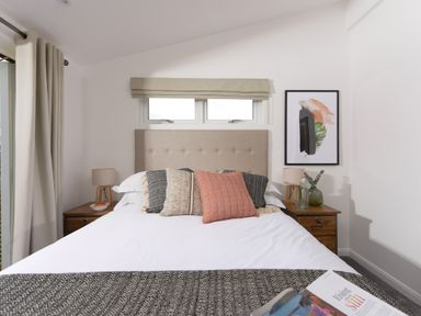 A bedroom with a bed with pillows two bedside tables with lamps and a framed artwork on the wall at 5 Southern Place in Dobwalls