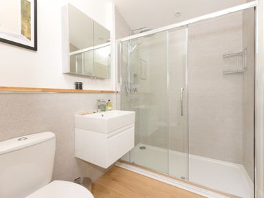 A bathroom with a toilet sink shower enclosure and mirrored cabinet at 5 Southern Place in Dobwalls