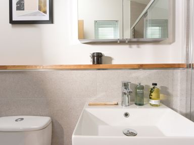 A bathroom sink with soap bottles and a toothbrush next to a toilet at 5 Southern Place in Dobwalls