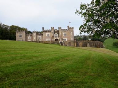 A castle view on a grassy landscape at Watermouth Castle, Rhododendron Apartment in Berrynarbor near Ilfracombe