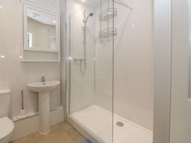 A bathroom with a toilet sink shower and mirror at Ger Y Lli in Rhosneigr