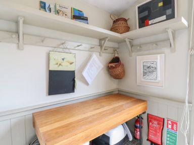A utility room with a table and storage shelves at The Artist's Cabin By The Sea in Herne Bay