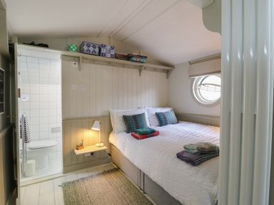 A bedroom with a bed and shower area at The Artist's Cabin By The Sea in Herne Bay
