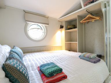 A bedroom with a bed and shelves at The Artist's Cabin By The Sea, Herne Bay