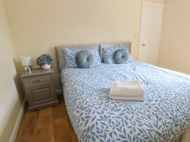A bedroom with a bed and bedside table at The Bevan in Bontnewydd, Gwynedd