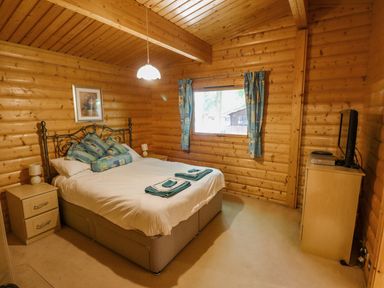 A bedroom with a bed pillows bedside tables a window and a television at Bamboo Retreat in Louth