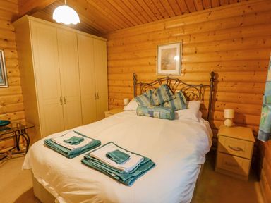 A bedroom with a bed pillows folded towels wardrobe bedside tables and lamps at Bamboo Retreat in Louth