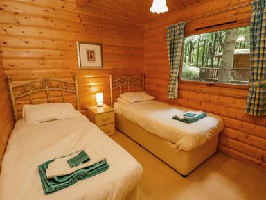 A bedroom with two single beds and a window showing trees at Bamboo Retreat in Louth