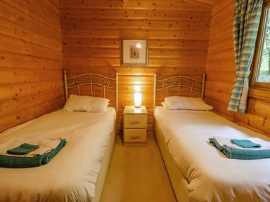 A bedroom with two single beds separated by a nightstand with a lamp at Bamboo Retreat in Louth