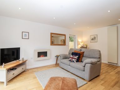 A living room with a sofa and TV at Mariners Rest in Gorran Haven