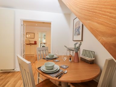 A dining room with a round table set for two at Mariners Rest in Gorran Haven