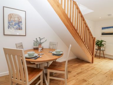 A dining area with a round table and chairs at Mariners Rest in Gorran Haven
