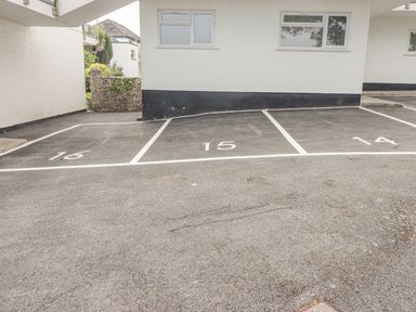 Three numbered parking spaces 16 15 and 14 in front of a white building with two windows at 16 Coedrath Park in Saundersfoot