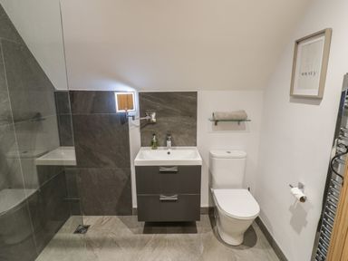 A bathroom with a toilet sink and shower at The Stables in Droitwich Spa
