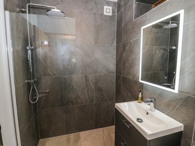 A bathroom with a walk-in shower and a sink with a mirror at The Stables in Droitwich Spa