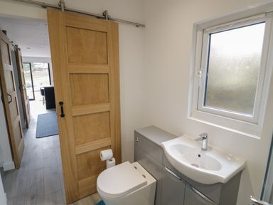 A small bathroom with a toilet sink and frosted window at Goldthorne Lodge in Clee Hill