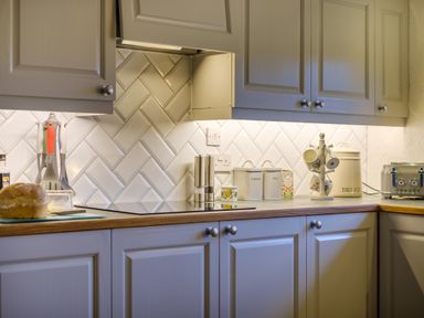 A kitchen countertop with cabinets a bread loaf utensils a toaster and containers labeled coffee tea and bread at Sunny Brae in Lindale