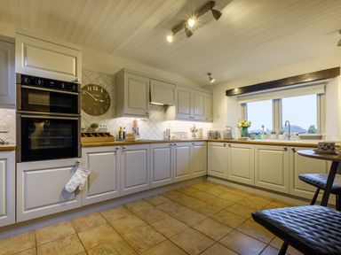 A kitchen with white cabinets, double oven, countertop appliances, and a window with a view at Sunny Brae in Lindale