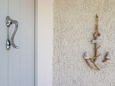 A door handle and a decorative anchor on a wall at Hafod Y Bryn Harlech