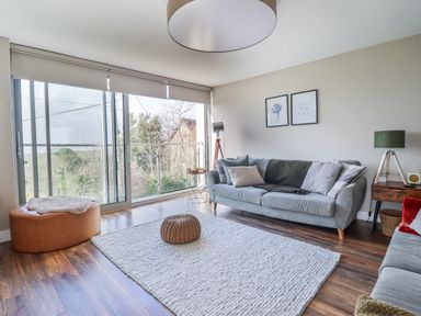 A living room with a sofa and window at Hafod Y Bryn in Harlech