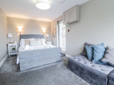 A bedroom with a bed and sofa at Hafod Y Bryn in Harlech