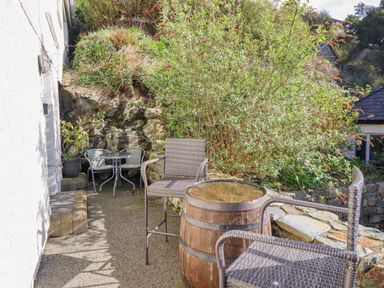 A garden area with table and chairs and greenery at Hafod Y Bryn in Harlech