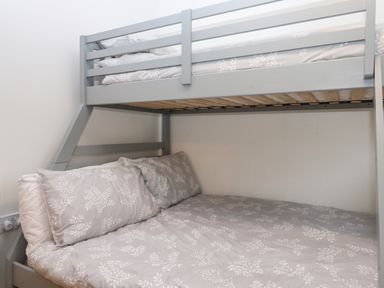 A bunk bed with gray and white patterned bedding in a bedroom at 2 The Glade in Kilkhampton