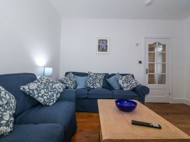 A living room with a sofa and coffee table at Ty Capel Bethania in Nant Gwynant