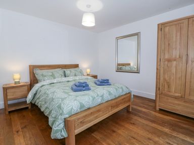 A bedroom with a bed and wardrobe at Ty Capel Bethania in Nant Gwynant
