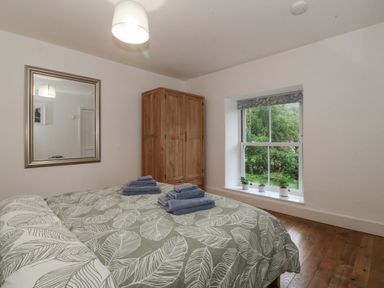 A bedroom with a bed and wardrobe at Ty Capel Bethania in Nant Gwynant
