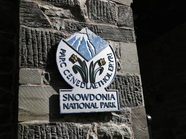 A sign for Snowdonia National Park on a stone wall