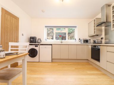 A kitchen with washing machine dishwasher oven microwave and toaster at Lakeside in Falmouth