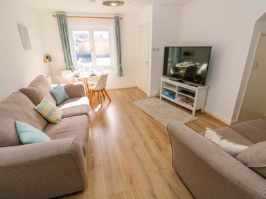 A living room with a sofa and dining table at No.22 The Clicketts Tenby
