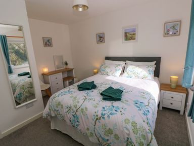 A bedroom with a double bed and side tables at No.22 The Clicketts in Tenby