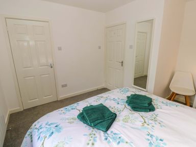 A bedroom with a bed and towels on top at No.22 The Clicketts Tenby