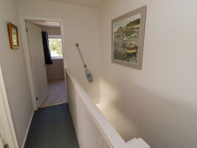 A hallway with a painting on the wall at Lavender Cottage in Beadnell