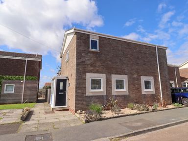 A house with a front door and windows at Lavender Cottage in Beadnell